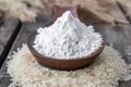 Rice flour in a spoon on a pile of white rice on old boards Royalty Free Stock Photo