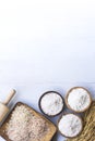 Rice flour in wooden bowl with white rice, Thai Native rice, rice ears, and paddy ear rice  on white wooden background Royalty Free Stock Photo