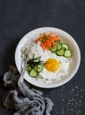 Rice with fried egg, pickled carrots, cucumber and seaweed. Healthy diet food concept. Top view Royalty Free Stock Photo