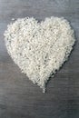 Rice grains formed in heart shape on wooden background Royalty Free Stock Photo