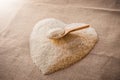 Rice laid out in a heart shape on sackcloth with wooden spoon Royalty Free Stock Photo