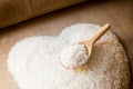 Rice laid out in a heart shape on sackcloth with wooden spoon Royalty Free Stock Photo