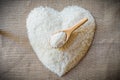 Rice laid out in a heart shape on sackcloth with wooden spoon Royalty Free Stock Photo