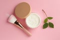 Rice loose face powder, makeup brush and branch on pink background, flat lay Royalty Free Stock Photo