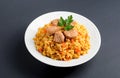 Rice with meat on a white plate. Pilaf on gray background