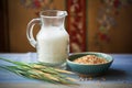 rice milk in a jug, unhulled rice grains on the side Royalty Free Stock Photo