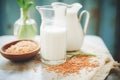 rice milk in a jug, unhulled rice grains on the side Royalty Free Stock Photo