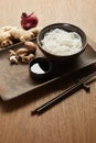rice noodles in bowl near chopsticks, soy sauce, ginger root, onion and on wooden tray Royalty Free Stock Photo