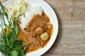 Rice noodles dressing with meat ball fish coconut milk curry sauce and fresh vegetable on plate Royalty Free Stock Photo