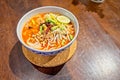 Rice noodles with spicy pork sauce in bowl on wooden table. The local food of northern`s Thailand, call `Khanom Jeen Nam Ngeaw
