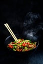 Rice noodles with vegetable stir fry on the ceramic plate on dark background Royalty Free Stock Photo