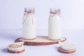 Rice and oat vegan milk in glass bottles on a wooden stand