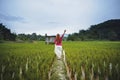 Woman raising her hand in a rice paddy farm.