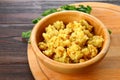 Rice pilaf with chicken, spices and parsley in a bowl on a wooden table.