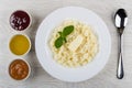 Rice porridge with butter, mint in plate, jam, honey, spoon Royalty Free Stock Photo