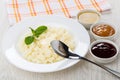 Rice porridge with butter in plate, jam, honey, spoon, napkin Royalty Free Stock Photo