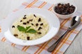 Rice porridge with mint, raisin in plate, dried grape, spoon