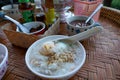 Rice porridge with parboiled egg, minced pork and pepper on wooden table, rice gruel or congee in forest. Royalty Free Stock Photo