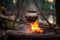 rice pot hanging from a tripod over a campfire