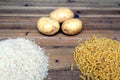 Rice, potatoes and macaroni pasta on a wooden table.Three common carbohydrates which provide energy but can cause obesity Royalty Free Stock Photo