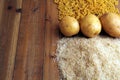 Rice, potatoes and macaroni pasta on a wooden table.Three common carbohydrates which provide energy but can cause obesity Royalty Free Stock Photo