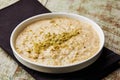 Rice pudding porridge, kheer, khir or firini sweet topping with pistachio served in dish isolated on table top view of arabic