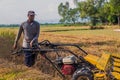 Rice reaper harvester machine in agriculture of remote village, Man using paddy cutting machine in a rural village