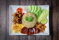 Rice seasoned with shrimp paste or rice mix slice of red onion, bean,mango, fried egg, Thai Food on wooden background. Royalty Free Stock Photo