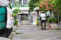 Rice sellers ride a bicycle after heavy rain