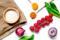 Rice, spices and vegetables for paella on white desk background top view