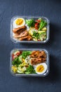 Rice, stewed vegetables, egg, teriyaki chicken - healthy balanced lunch box on a dark background, top view. Home food for office Royalty Free Stock Photo