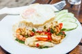 Rice topped with stir-fried combination of pork, chicken, squid, shrimp, basil and fried egg. Thai food Royalty Free Stock Photo