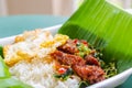 Rice topped with stir-fried pork, basil leaves and chili served