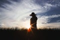 Autumn rice field landscape with ripening grain, farmer and sunset background Royalty Free Stock Photo