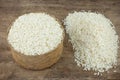 Rice in a wicker rice and scattered near on dark wooden table