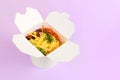 Rice wok with seafood and vegetables in white box isolated on purple background, takeaway food Royalty Free Stock Photo