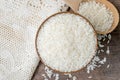 Rice in wooden bowl with wood ladle and white tablecloth on old wood texture background Royalty Free Stock Photo