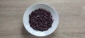 Riceberry in a white plate, placed on a wooden table, top view