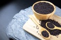 Riceberry in a wooden cup and wooden spoon placed on a wooden tray, Oblique angle