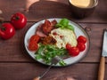 Rich breakfast of omelet with grilled sausage and fresh tomatoes and fresh atromatous herbs, cutlery on a wooden tray Royalty Free Stock Photo