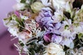 Rich bunch of pink peonies and lilac eustoma roses flowers, green leaf in glass vase. Royalty Free Stock Photo