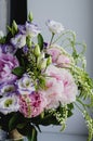 Rich bunch of pink peonies peony and lilac eustoma roses flowers in glass vase on white background. Rustic style, still Royalty Free Stock Photo