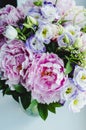 Rich bunch of pink peonies peony and lilac eustoma roses flowers in glass vase on white background. Rustic style, still life. Royalty Free Stock Photo