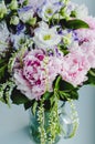 Rich bunch of pink peonies peony and lilac eustoma roses flowers in glass vase on white background. Rustic style, still life. Royalty Free Stock Photo