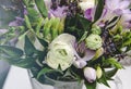 Rich bunch of white buttercup ranunculus and lilac fresia, roses flowers, green leaf in glass vase. Fresh spring summer Royalty Free Stock Photo