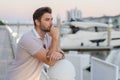 Rich business man dreaming and thinking near the yacht. Handsome confident stylish hipster model posing outside. Sexy Royalty Free Stock Photo