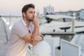 Rich business man dreaming and thinking near the yacht. Sexy man in casual clothes posing on the street. Successful male Royalty Free Stock Photo