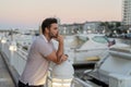 Rich business man dreaming and thinking near the yacht. Urban fashion man in city walking street. Portrait of stylish Royalty Free Stock Photo