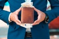 Rich businessman in a blue jacket shows off a leather brown wallet full of euro cash. Close-up of the hands. The concept Royalty Free Stock Photo