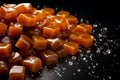 Rich caramels tempt on a dark background, ideal for text